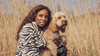 Woman with a dog sitting in a field during a UK road trip adventure